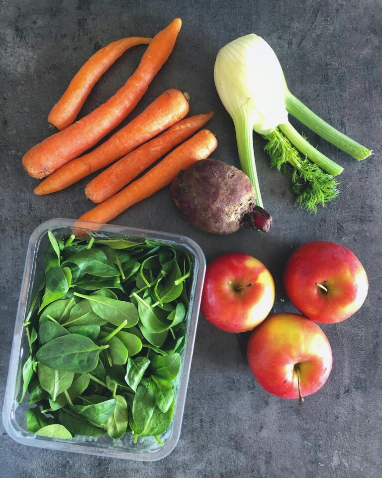 Colorful arrangement of fresh fruits and vegetables on dark background.